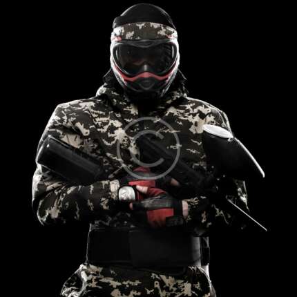 Heavily armed masked paintball soldier isolated on black background. Ad concept. Copy space.